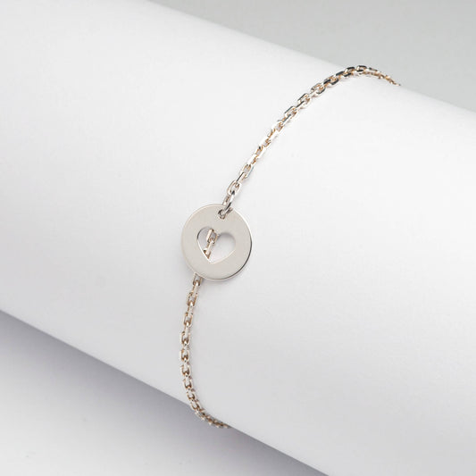 Srebrna  bransoletka z okrągłą zawieszką  z wyciętym symbolem serca.